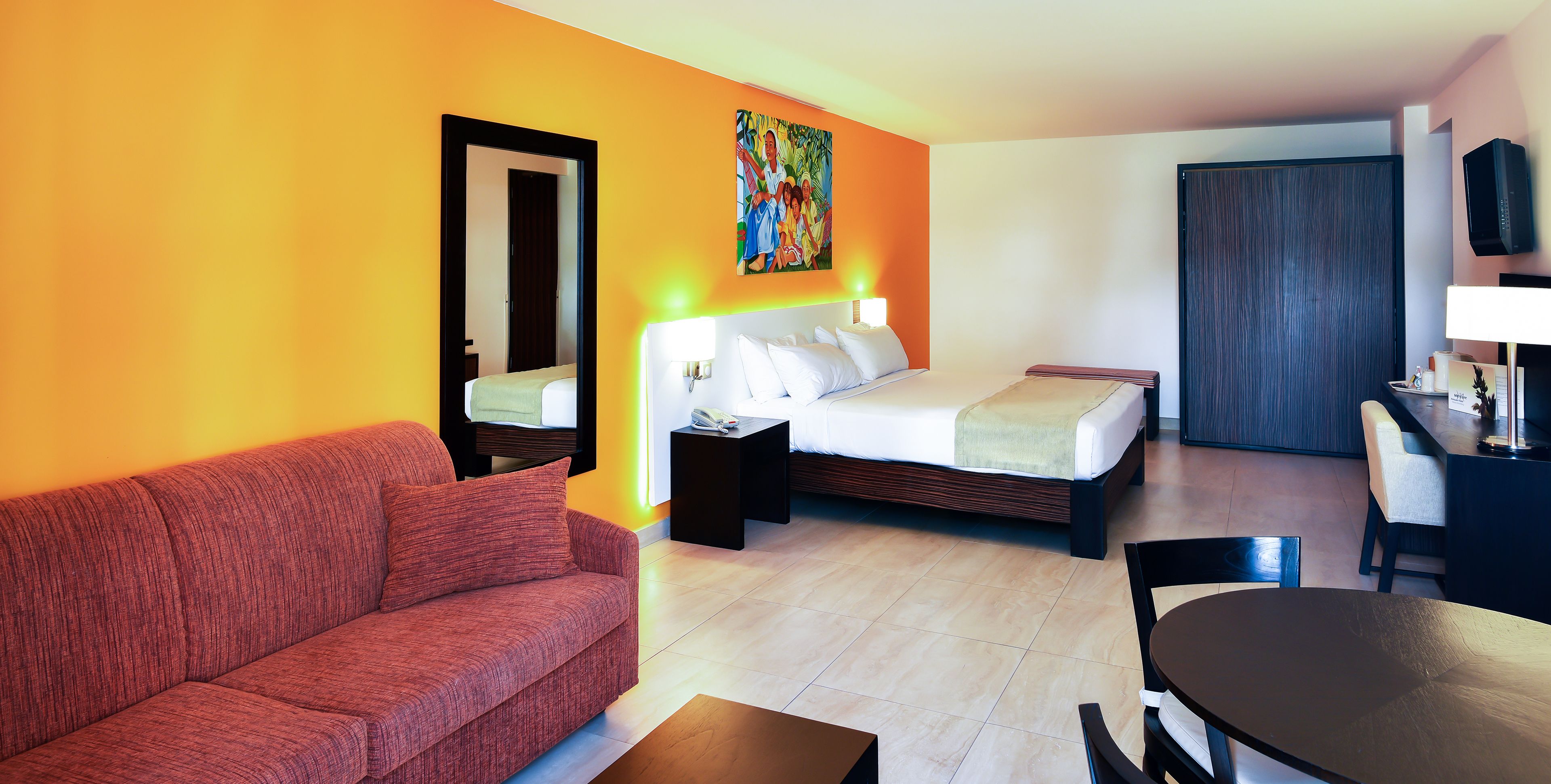 Une chambre d’hôtel avec un lit, un canapé, un bureau et une télévision.