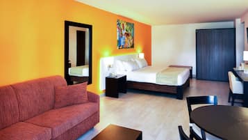 Une chambre d’hôtel avec un lit, un canapé, un bureau et une télévision.