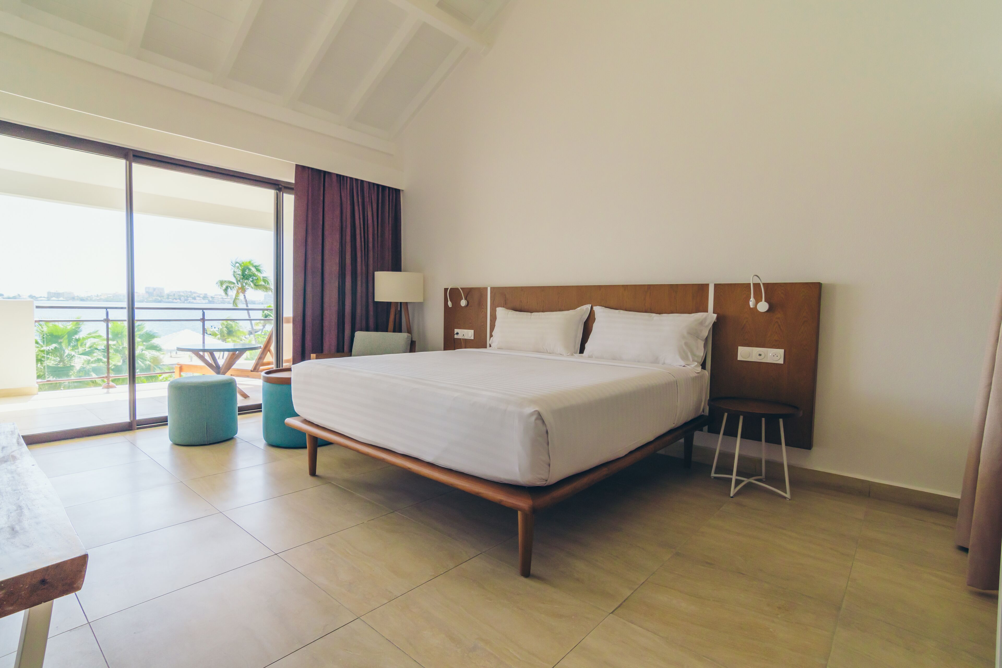 A hotel room with a large bed, a desk, and a view of the outdoors.