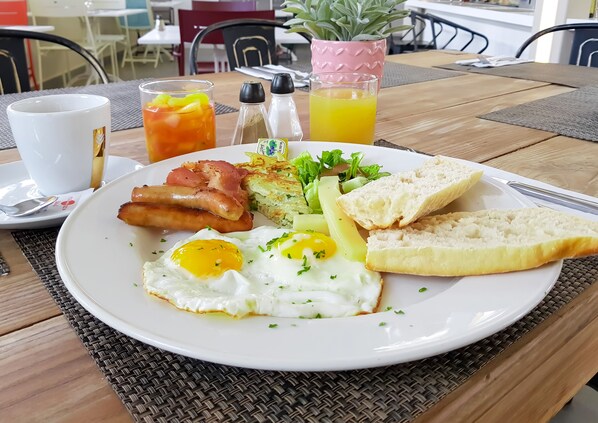Un plato de desayuno con huevos, tocino, patatas ralladas, tostadas y una ensalada.