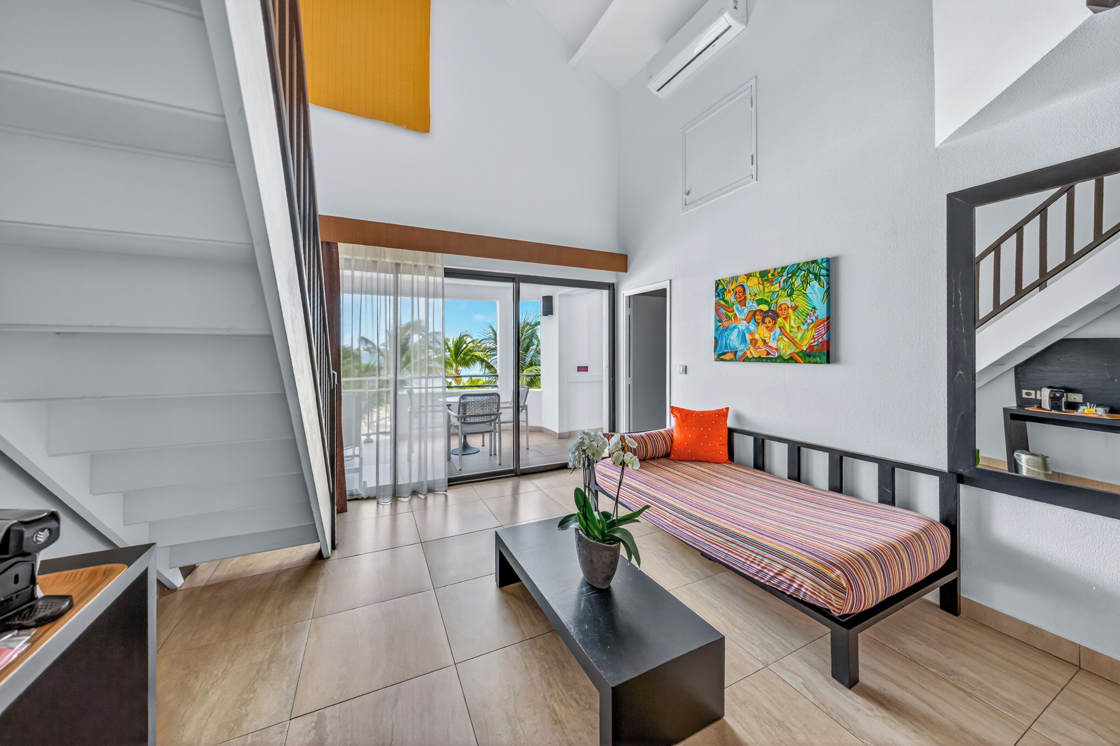Una sala de estar moderna con un sofá, una mesa de centro y una escalera.