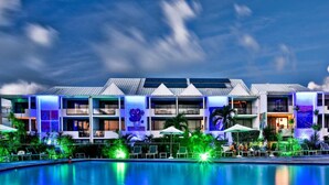 A hotel with multiple floors, a swimming pool, and outdoor seating areas. - Hommage Hotel & Residences (Nettle Bay)