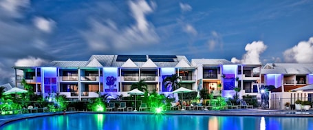 A hotel with multiple floors, a swimming pool, and outdoor seating areas.