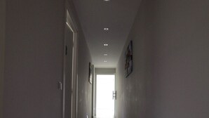 A long, narrow hallway with a tiled floor and recessed lighting. - Chiaia Guest House (Naples)