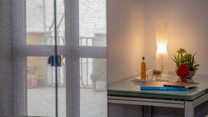 A room with a large window, a table with books, a candle, and a plant. - Brio Bed & Breakfast (Agrigento)