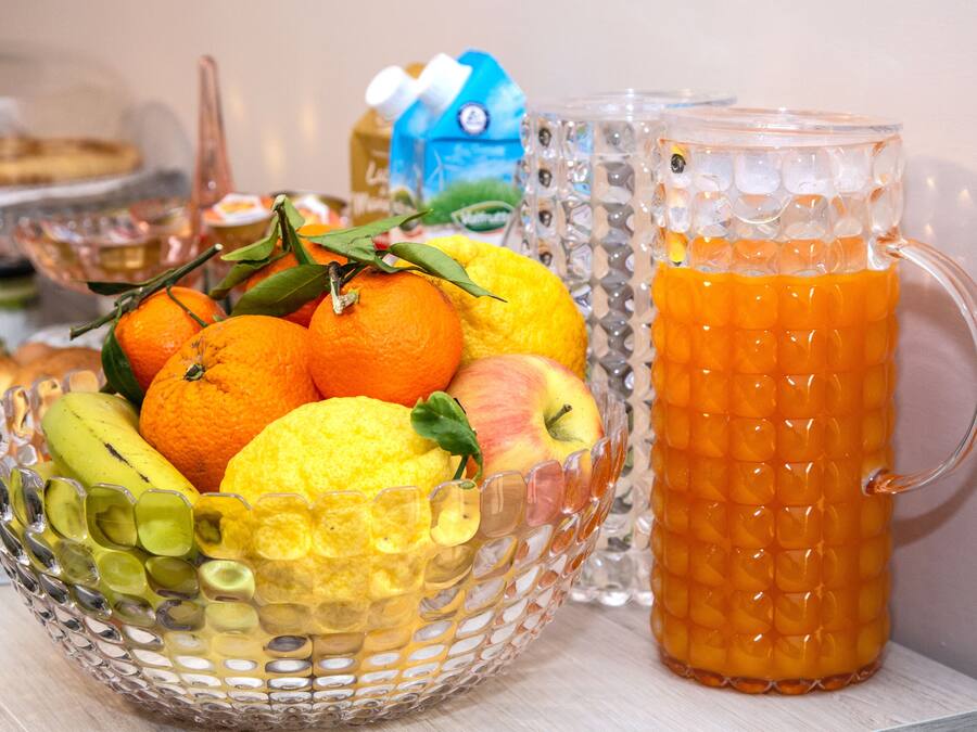 En skål med frugt og en kande appelsinjuice.