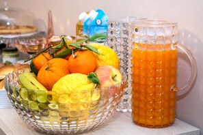A glass bowl filled with fruits and a glass pitcher of orange juice. - Brio Bed & Breakfast (Agrigento)