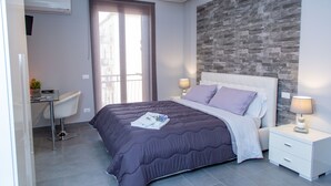 A modern bedroom with a large bed, a desk, and a chair. - Brio Bed & Breakfast (Agrigento)