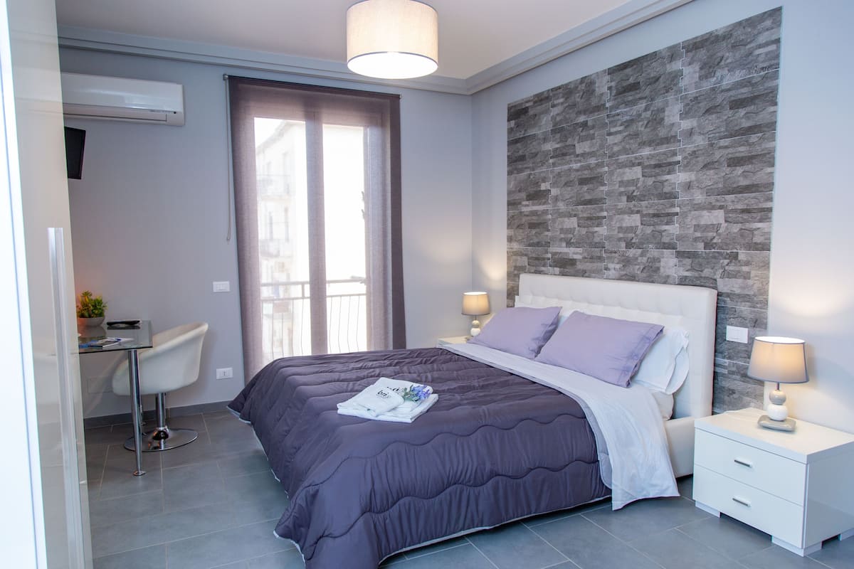 Un dormitorio moderno con una cama grande, un escritorio y una silla.
