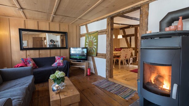 Een gezellige woonkamer met een open haard, een televisie en een bank.