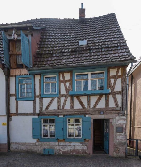 A traditional half-timbered house with a tiled roof, multiple windows with shutters, and a visible chimney. - Historisches Gerberhaus (Alpirsbach)