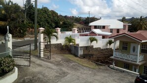 A residential area with houses, a gated entrance, and a paved road. - Winfort 4 Bay Walk (Gros Islet)