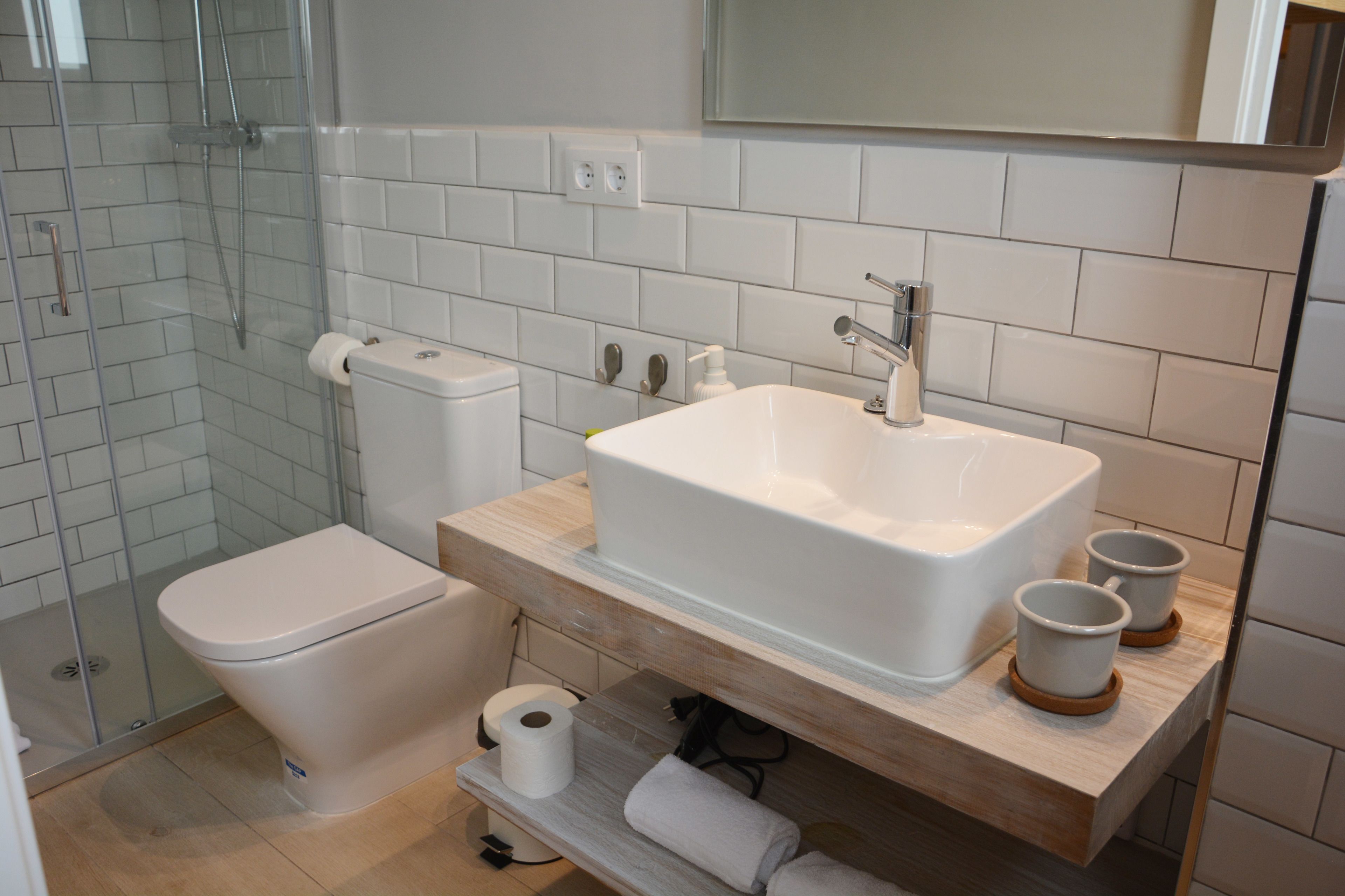 Une salle de bain moderne équipée de toilettes, d’un lavabo et d’une douche.
