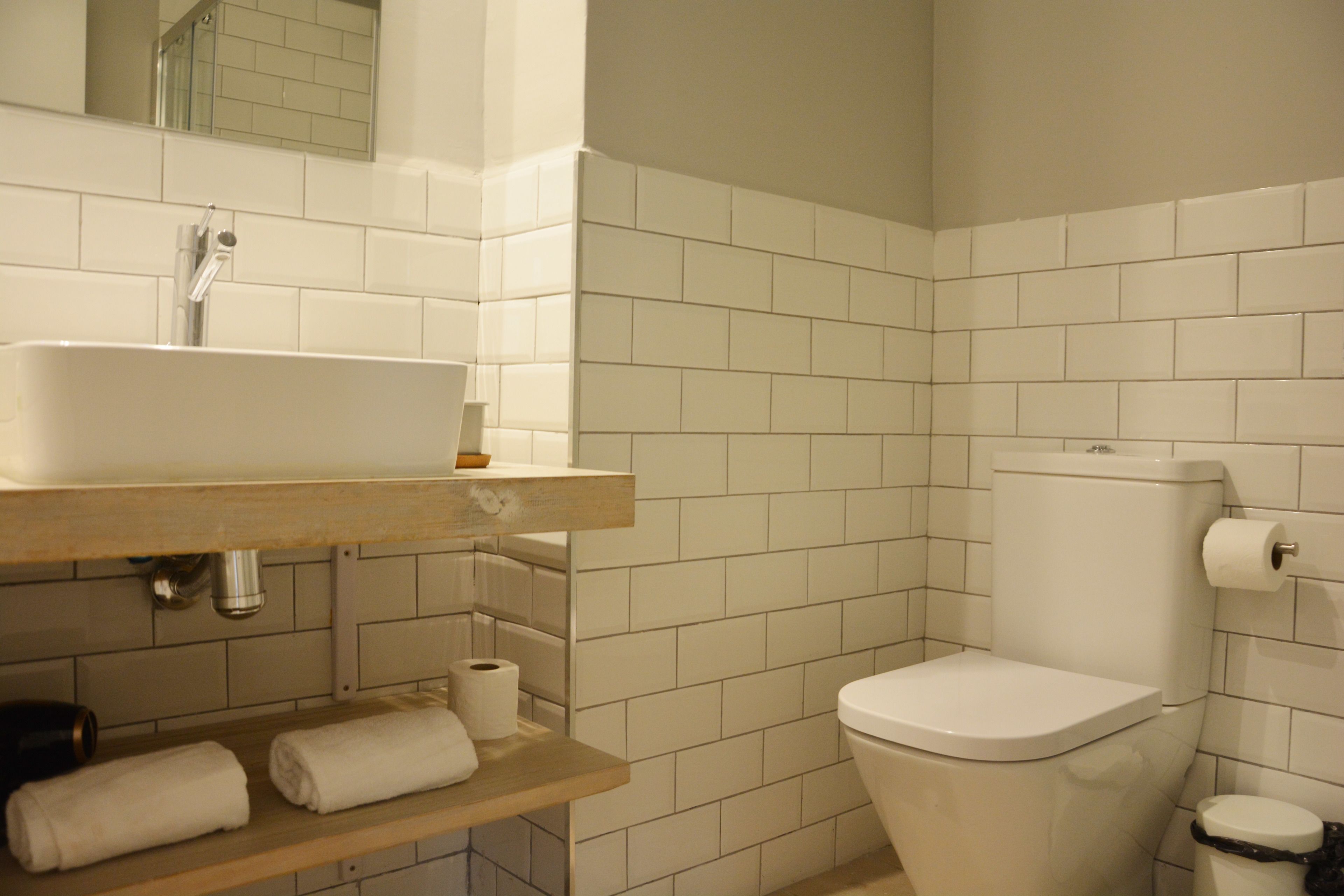 Ein Badezimmer mit weißem Waschbecken, Toilette und Spiegel über dem Waschbecken.