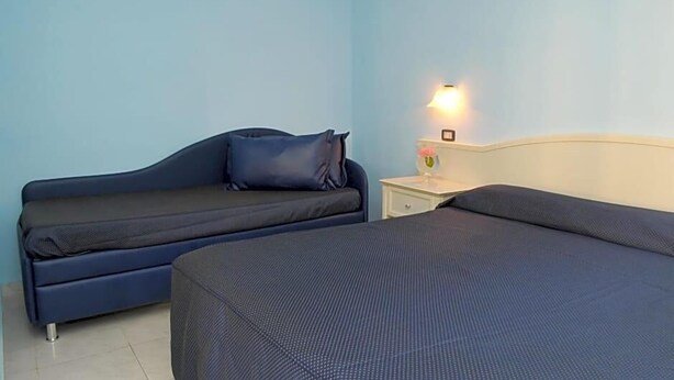 A room with a bed, a sofa, and a nightstand with a lamp. - La Sorgente (Capaccio-Paestum)