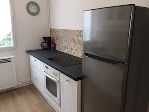 A kitchen with a stainless steel refrigerator, a coffee maker, and patterned backsplash tiles. - "CHEZ VIORIKA" Apartment: 3 Bedrooms, 4 Beds, Parking (Rouen)