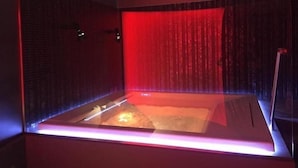 A modern bathroom with a glass enclosure, red lighting, and a visible shower area. - Hotel Tiro a Volo (Pozzuoli)