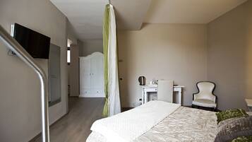 A bedroom with a bed, a desk, a chair, a television, and a staircase.