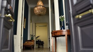 A grand hallway with a chandelier, a piano, and a sofa. - B&B Kwaadham 52 - Music Hotel Ghent (Ghent)