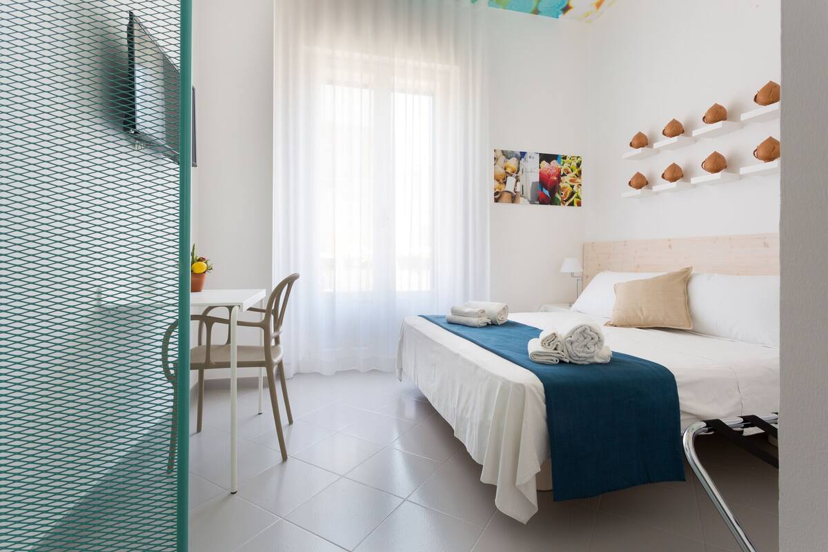 Una habitación de hotel con una cama, un escritorio y una silla.