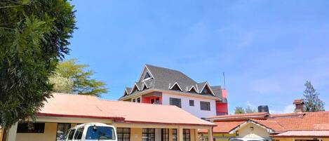 A building with a red roof and a white van parked in front.
