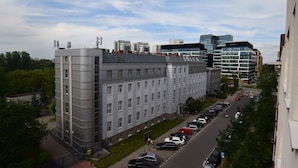 A multi-story building with a parking lot in front. - Elegant Apartment Arkadia (Warsaw)
