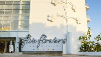 Un edificio con una gran escultura floral y el texto "five flowers hotel spa formatera".