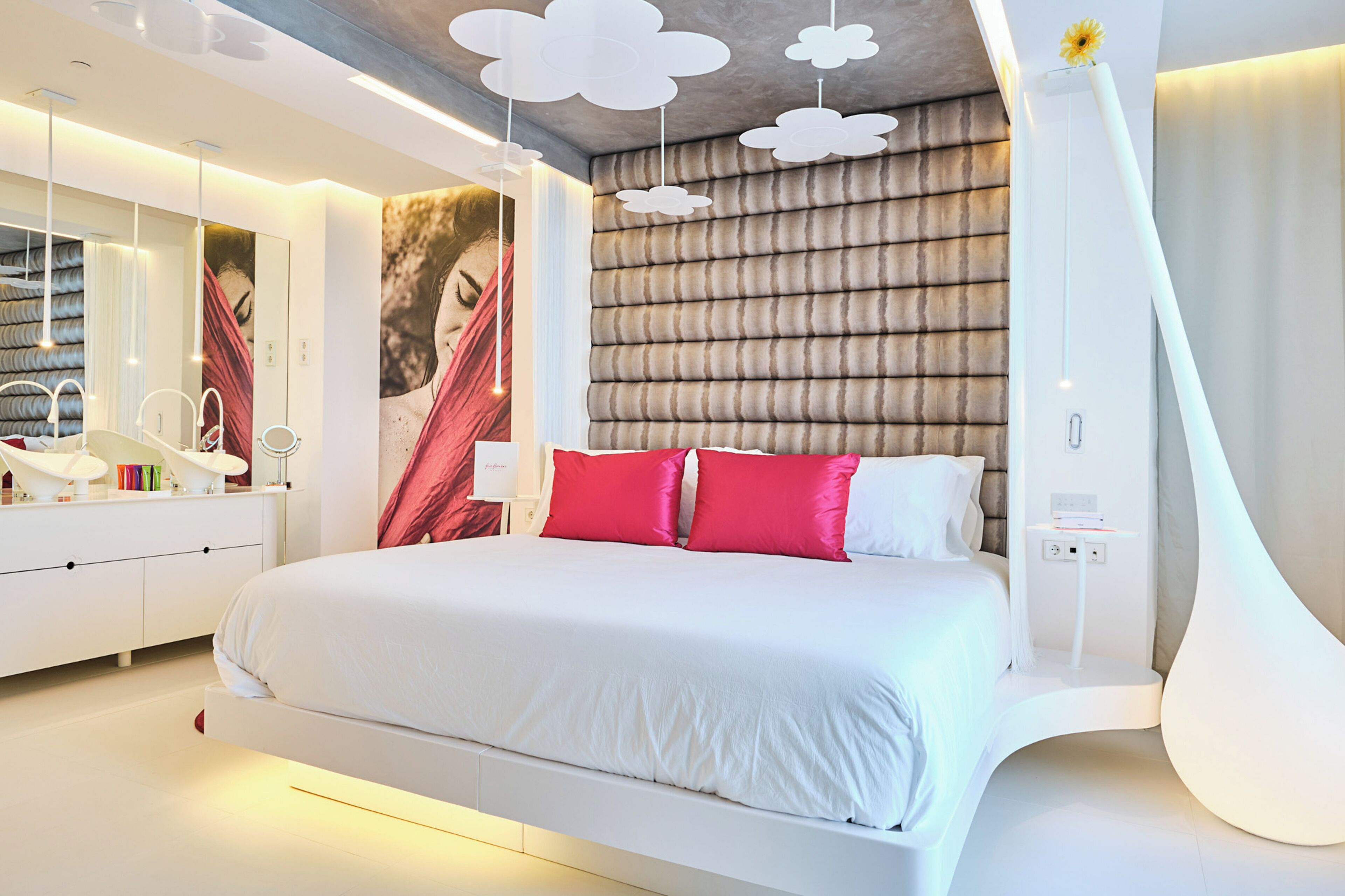 Un dormitorio moderno con una cama grande, un tocador con espejo y un diseño de techo original.