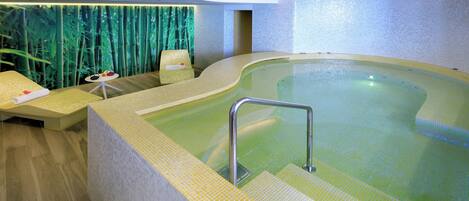 Un área de spa con un jacuzzi, asientos y una pared con motivos de bambú.