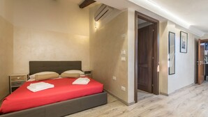 A bedroom with a bed, bedside tables, and a door leading to another room. - Red Lion Guest House (Mestre)