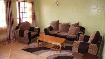 A living room with a sofa set, a wooden coffee table, and a small side table.