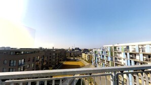 En hög byggnad med många våningar, avsedd för bostäder, med flera balkonger och fri utsikt över det omgivande stadsområdet.