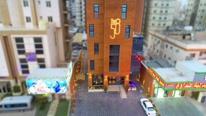 Un edificio moderno con un llamativo letrero que dice '50' en la fachada, rodeado de otros edificios.