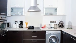 A modern kitchen with a built-in oven, microwave, toaster, coffee maker, and a washing machine. - Natalie Villa CL 41 (Paralimni)