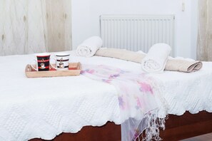 A neatly made bed with white linens, a floral throw blanket, and two mugs with a coffee theme. - Natalie Villa CL 41 (Paralimni)