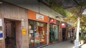 A storefront with a 'WIND' sign, a 'I ♥ CENTRO' sign, and a 'VENDE' sign. - La Terrazza di Anna (Sassari)
