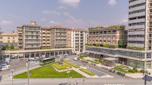 Un edificio residencial de varios pisos con balcones, una zona de estacionamiento y un espacio verde central.