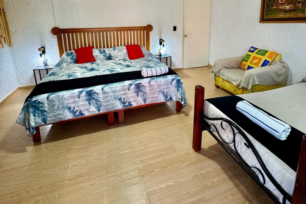 Una camera da letto con un letto, un comodino, una sedia e una porta.