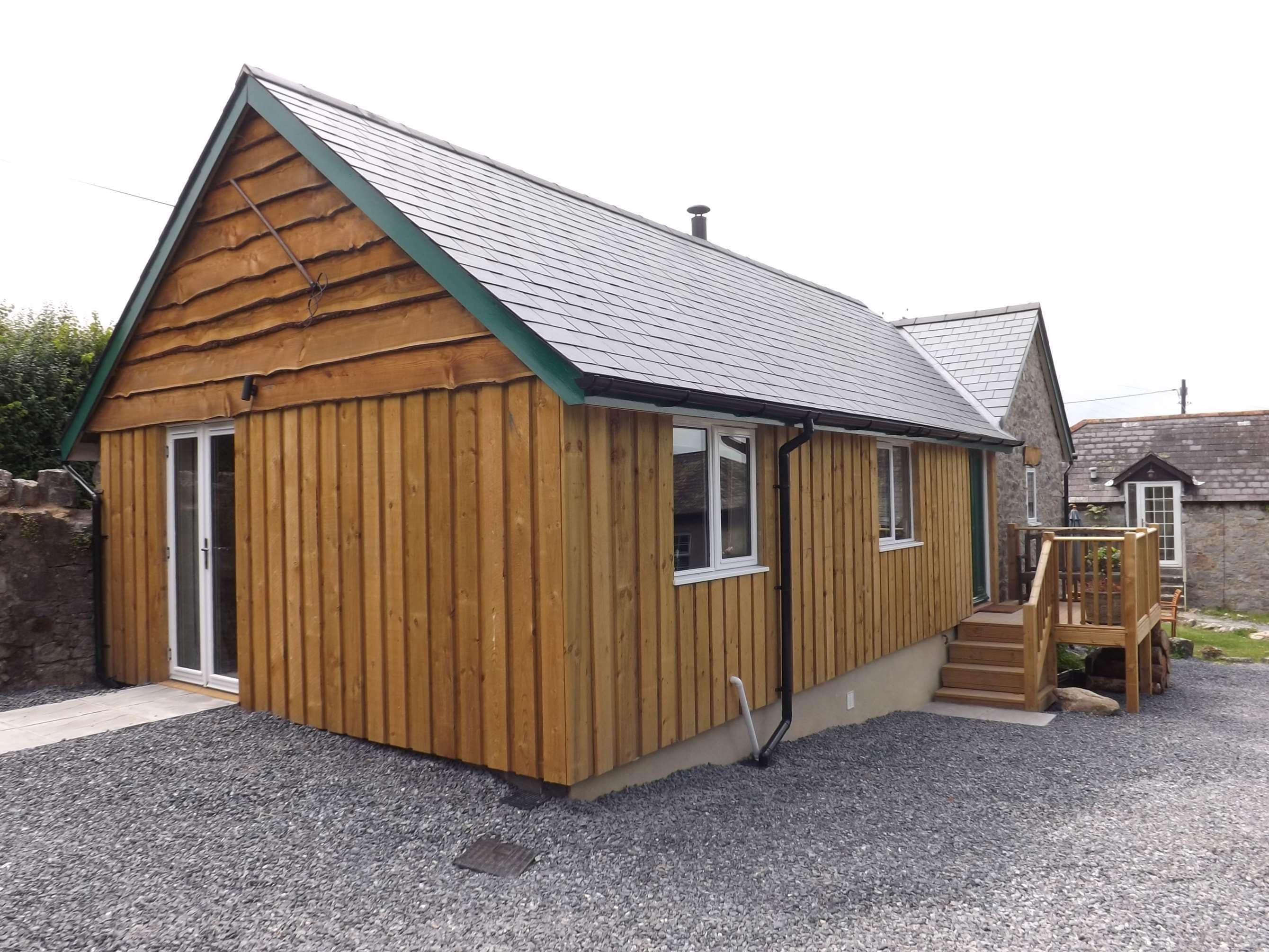 Un petit bâtiment en bois, doté d’un toit en pente, d’une porte et de fenêtres.