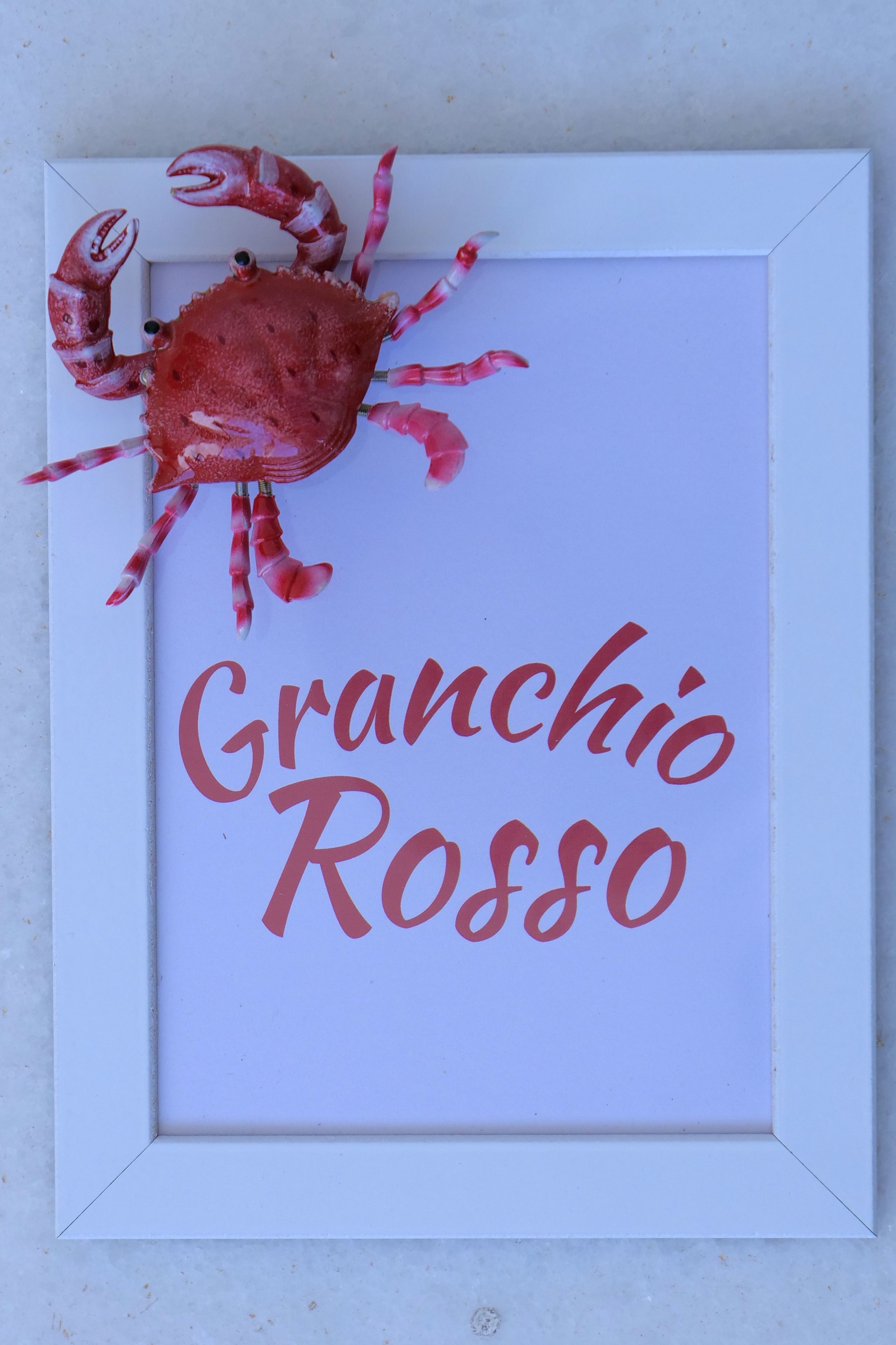A framed artwork with a crab and the text "Granchio Rosso".