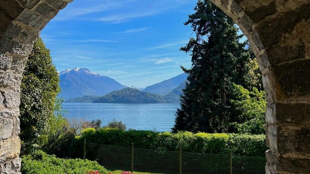 A stone archway leading to a patio with a view of a lake and mountains. - Situated in a beautiful & relaxing place on Lake Como,. Perfect family of 4. (Musso)
