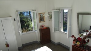 A bedroom with a bed, a dresser, a mirror, and two windows. - Situated in a beautiful & relaxing place on Lake Como,. Perfect family of 4. (Musso)