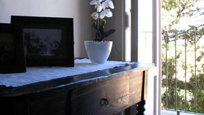 A room with a wooden desk, a white orchid in a white pot, and a framed picture on the wall. - A holiday home in the Iblea countryside a stone's throw from the sea (Ragusa)