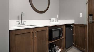 A kitchen with a sink, microwave, and coffee maker.