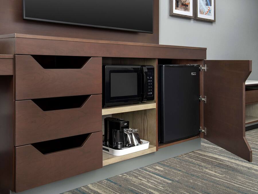 A kitchenette with a microwave, coffee maker, and a small refrigerator.