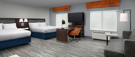A hotel room with two beds, a desk, a TV, and a chair.