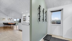 A modern kitchen with a central island, a dining area with a table and chairs, and a large window providing a view of the outside.