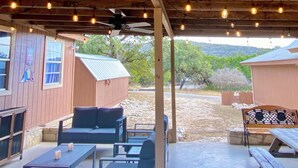 A covered outdoor patio with wooden furniture, a bench, and a table. - Fantastic Pool, Hot Tub, Cabana, Mt. Views, Party Pavilion, 2 Minutes 2 Frio! (Concan)
