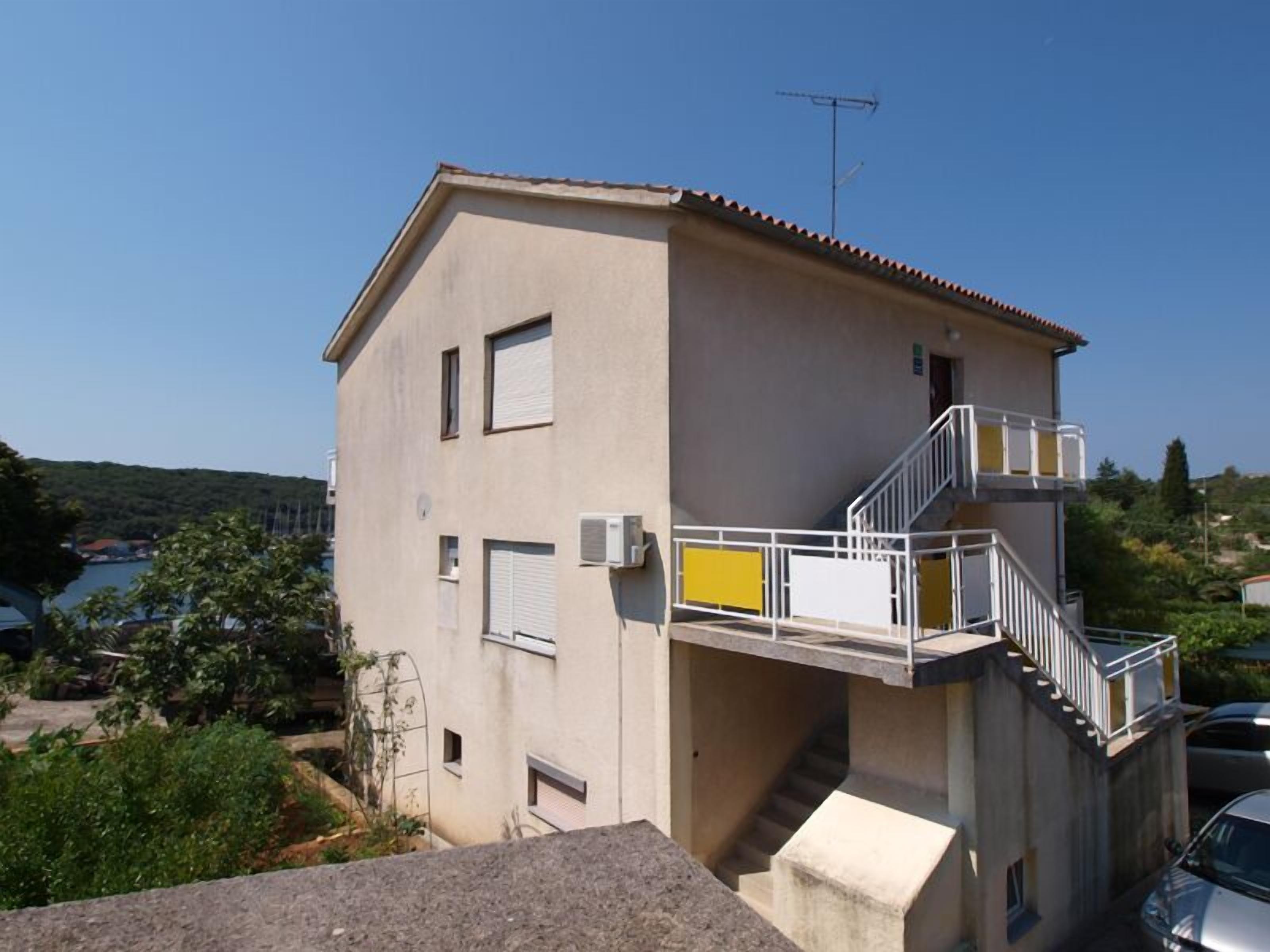 A two-story building with a balcony and a staircase.