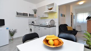 Una cocina compacta con comedor, lavadora y sofá.